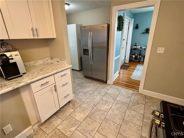 153 Milnor Ave, Syracuse, NY 13224 - kitchen featuring stainless steel fridge, white cabinetry, light stone countertops, and range