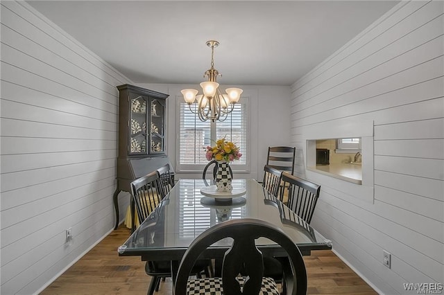 72 Old Lyme Dr Unit 3, Amherst, NY 14221 - dining room with a chandelier, wood walls, and wood finished floors
