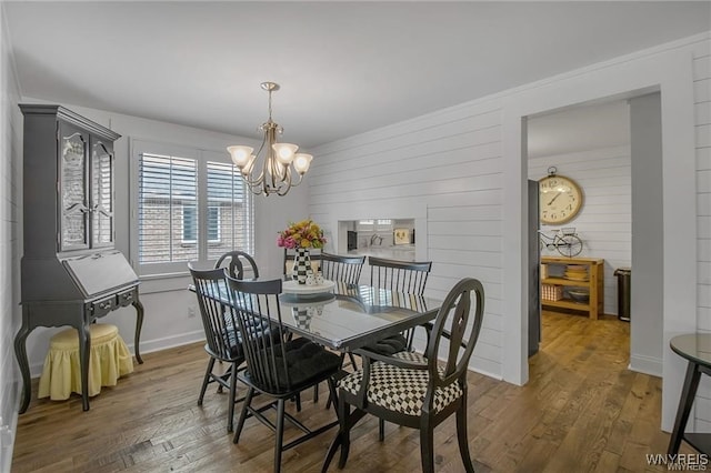72 Old Lyme Dr Unit 3, Amherst, NY 14221 - dining room with a chandelier, wood finished floors, and wood walls