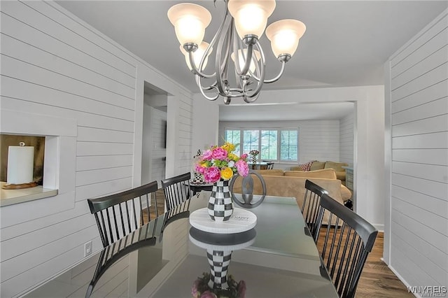 72 Old Lyme Dr Unit 3, Amherst, NY 14221 - dining space with wood walls, a chandelier, and wood finished floors