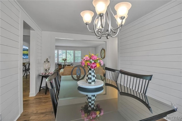 72 Old Lyme Dr Unit 3, Amherst, NY 14221 - dining space with wood finished floors, a chandelier, and wood walls