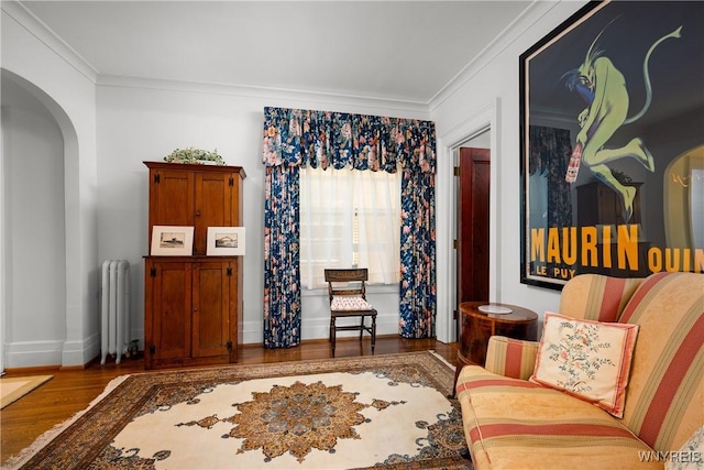 107 Oakland Pl Unit 1, Buffalo, NY 14222 - living area featuring radiator heating unit, arched walkways, wood finished floors, and ornamental molding