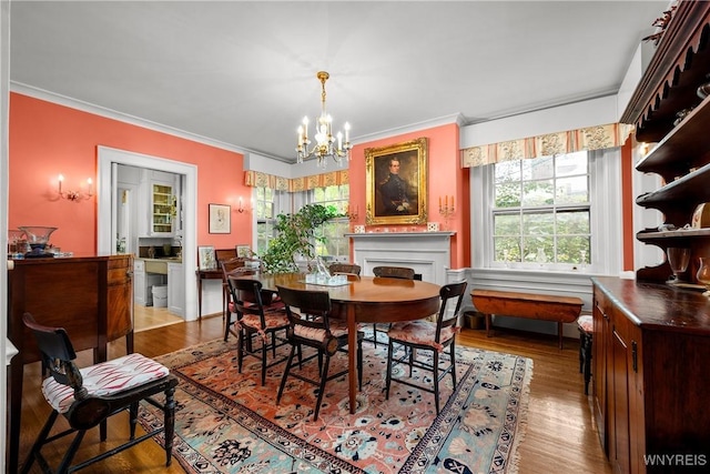 107 Oakland Pl Unit 1, Buffalo, NY 14222 - dining area featuring a chandelier, ornamental molding, wood finished floors, and a fireplace