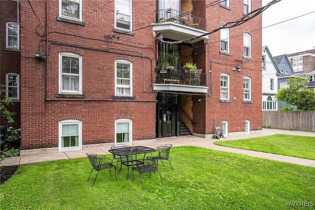 107 Oakland Pl Unit 1, Buffalo, NY 14222 - rear view of house featuring brick siding, a yard, and a balcony