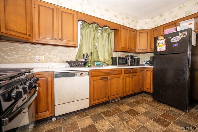 181 Ericson Ave, Buffalo, NY 14215 - kitchen with freestanding refrigerator, dishwasher, wallpapered walls, stainless steel range, and light countertops