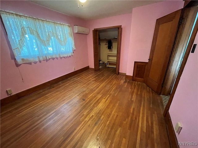2461 Linwood Ave, Niagara Falls, NY 14305 - unfurnished bedroom with a wall mounted air conditioner, wood finished floors, and a closet
