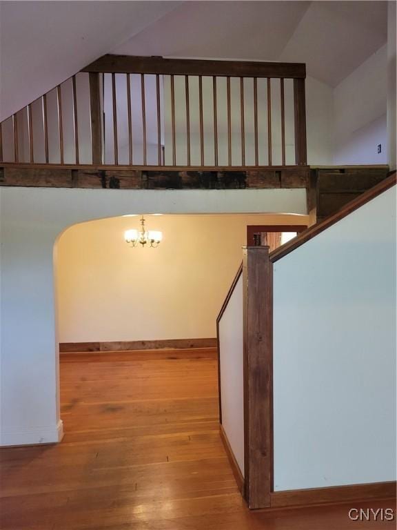 5465 Ridge Rd, Fleming, NY 13021 - staircase with wood finished floors, lofted ceiling, and a chandelier