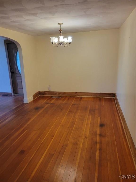 5465 Ridge Rd, Fleming, NY 13021 - unfurnished room featuring arched walkways, hardwood / wood-style floors, and a chandelier