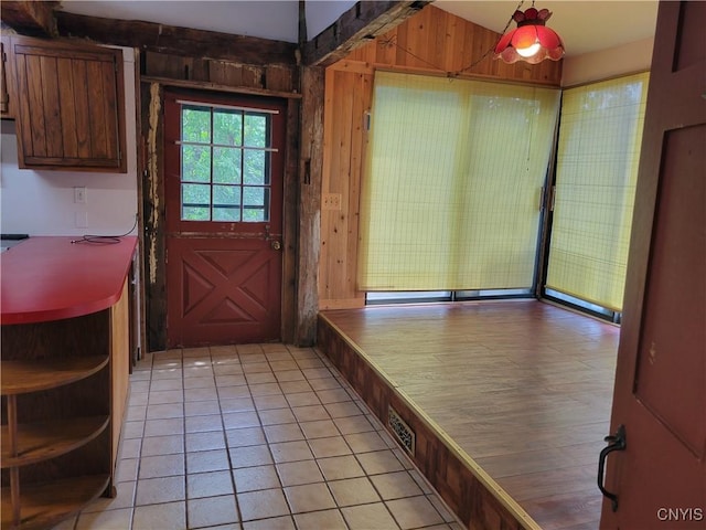 5465 Ridge Rd, Fleming, NY 13021 - doorway to outside with wooden walls and light tile patterned floors