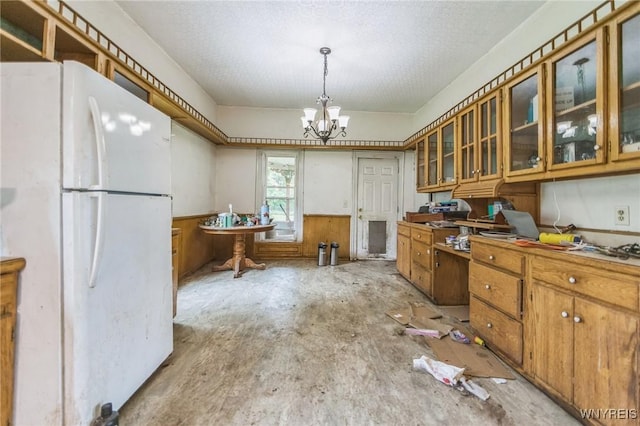 6192 Scudder Rd, Bath, NY 14879 - kitchen featuring freestanding refrigerator, brown cabinets, a chandelier, a desk, and a wainscoted wall