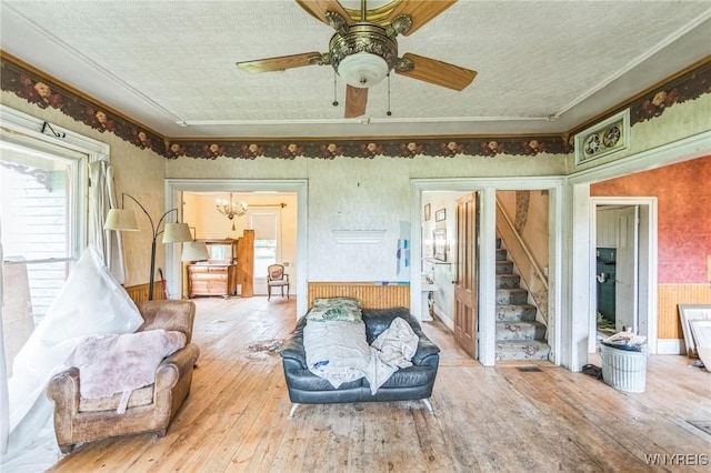 6192 Scudder Rd, Bath, NY 14879 - living area featuring wood-type flooring, stairs, ceiling fan, and ornamental molding