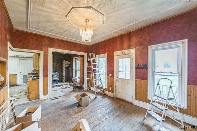6192 Scudder Rd, Bath, NY 14879 - entryway with hardwood / wood-style flooring, wainscoting, a chandelier, a wood stove, and wooden walls