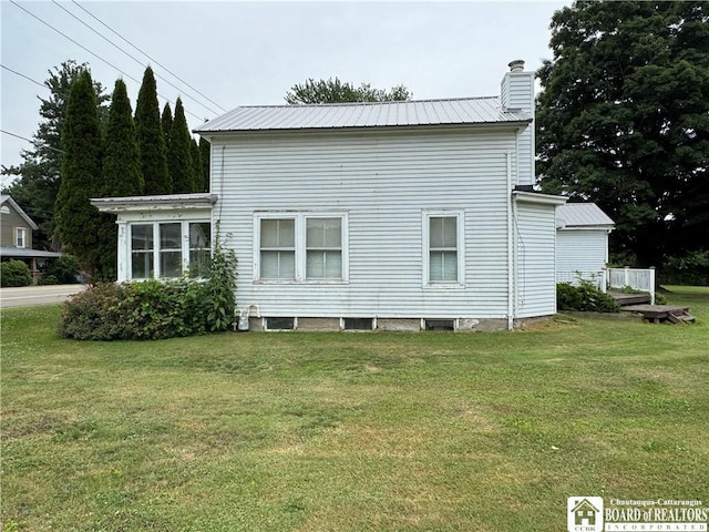 5469 E Lake Rd, Chautauqua, NY 14728 - view of side of home featuring a yard, a chimney, and a metal roof