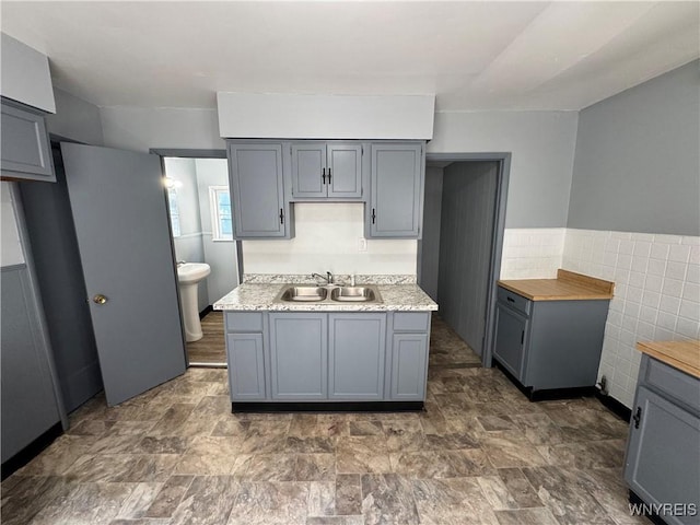 360 Longnecker St, Buffalo, NY 14206 - kitchen featuring gray cabinets, tile walls, light countertops, and a wainscoted wall
