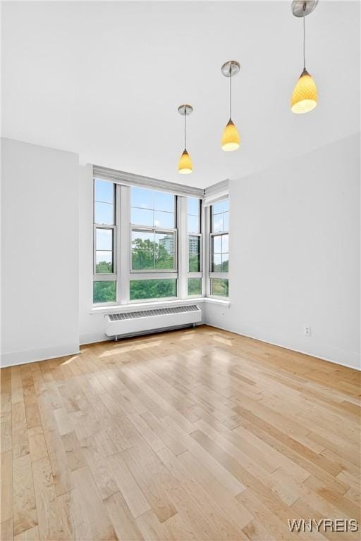 spare room with radiator and wood finished floors