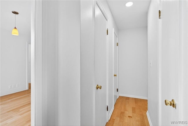 corridor featuring light wood-type flooring and recessed lighting