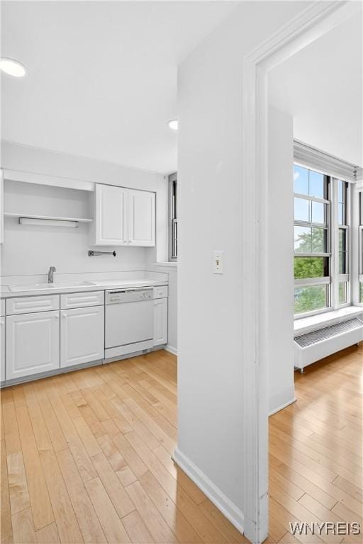 kitchen featuring white dishwasher, radiator, open shelves, white cabinetry, and light wood-type flooring