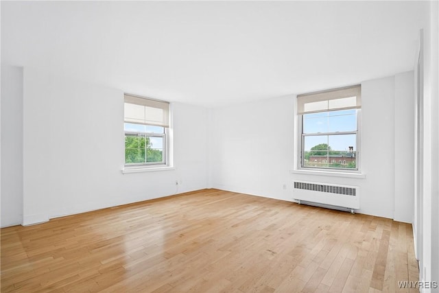unfurnished room with radiator and light wood finished floors