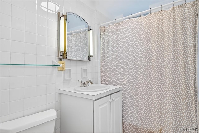 bathroom featuring vanity, a shower with shower curtain, and tile walls