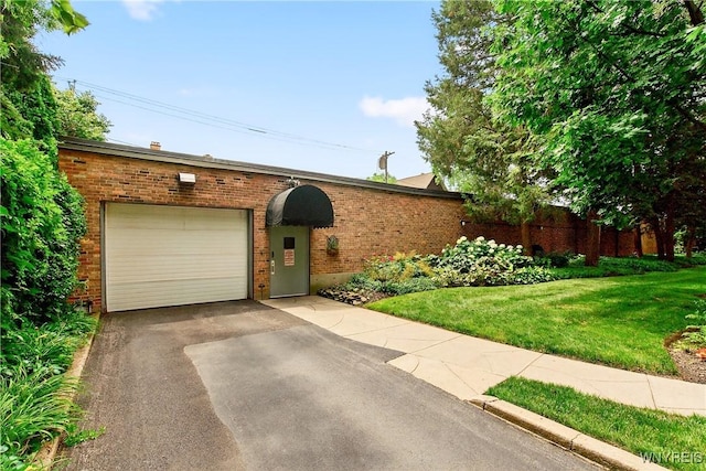 view of front facade with asphalt driveway, an attached garage, brick siding, and a front yard