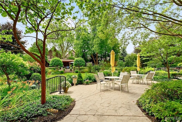 view of patio / terrace featuring outdoor dining area and view of wooded area