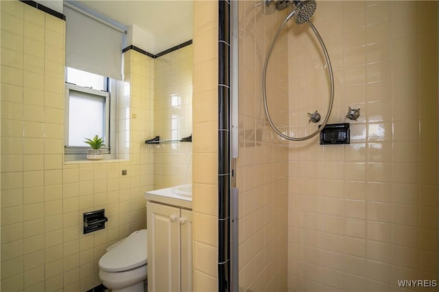 full bath featuring a stall shower, tile walls, and vanity