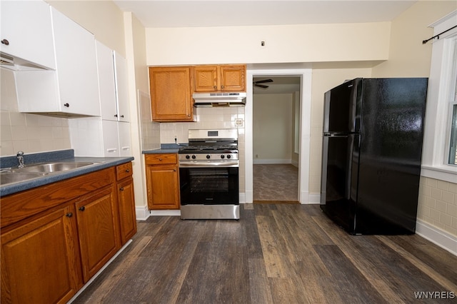2363 Niagara St, Buffalo, NY 14207 - kitchen with freestanding refrigerator, stainless steel range with gas stovetop, under cabinet range hood, dark wood-style floors, and dark countertops