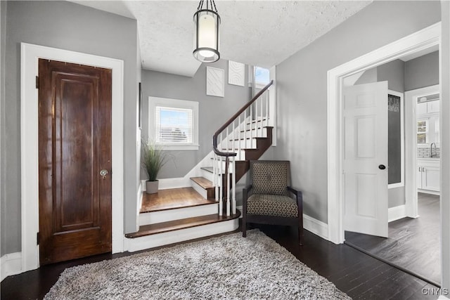 567 Grant Blvd, Syracuse, NY 13203 - foyer entrance with dark wood finished floors, stairs, and a textured ceiling