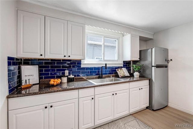 185 N Pleasant Pkwy, Cheektowaga, NY 14206 - kitchen featuring freestanding refrigerator, light wood finished floors, backsplash, white cabinetry, and dark stone counters