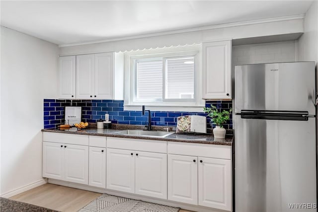 185 N Pleasant Pkwy, Cheektowaga, NY 14206 - kitchen featuring freestanding refrigerator, backsplash, light wood-style floors, white cabinets, and crown molding