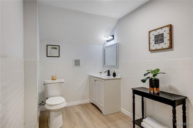 185 N Pleasant Pkwy, Cheektowaga, NY 14206 - bathroom with vanity, wood finished floors, tile walls, lofted ceiling, and wainscoting