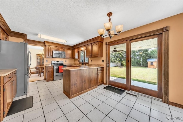 6103 Reger Dr, Lockport Town, NY 14094 - kitchen featuring stainless steel appliances, a peninsula, a chandelier, brown cabinets, and light countertops