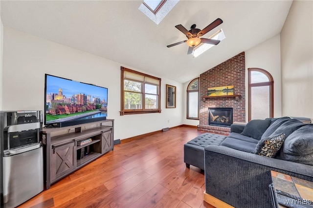 6103 Reger Dr, Lockport Town, NY 14094 - living area featuring a skylight, lofted ceiling, ceiling fan, wood finished floors, and a brick fireplace