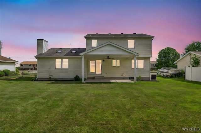 6103 Reger Dr, Lockport Town, NY 14094 - back of property featuring a ceiling fan, a patio, a lawn, and a chimney