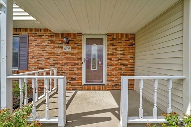 6103 Reger Dr, Lockport Town, NY 14094 - doorway to property featuring covered porch and brick siding
