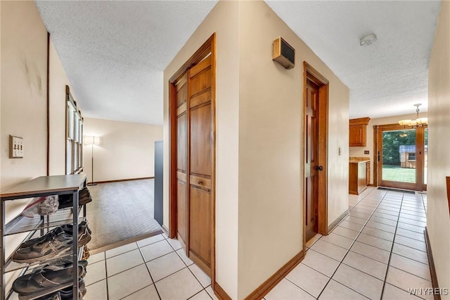 6103 Reger Dr, Lockport Town, NY 14094 - corridor with a textured ceiling, light tile patterned floors, a chandelier, and light colored carpet