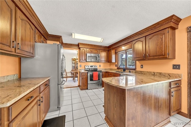 6103 Reger Dr, Lockport Town, NY 14094 - kitchen featuring appliances with stainless steel finishes, a peninsula, brown cabinetry, a textured ceiling, and light tile patterned floors