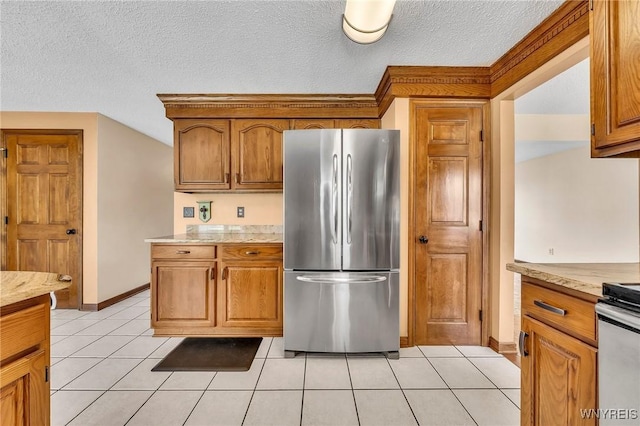 6103 Reger Dr, Lockport Town, NY 14094 - kitchen featuring freestanding refrigerator, light tile patterned floors, brown cabinetry, a textured ceiling, and range