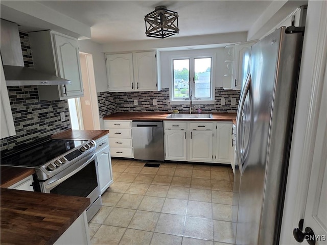 3978 Thrush Ln, Clay, NY 13090 - kitchen featuring appliances with stainless steel finishes, wood counters, wall chimney exhaust hood, backsplash, and white cabinetry