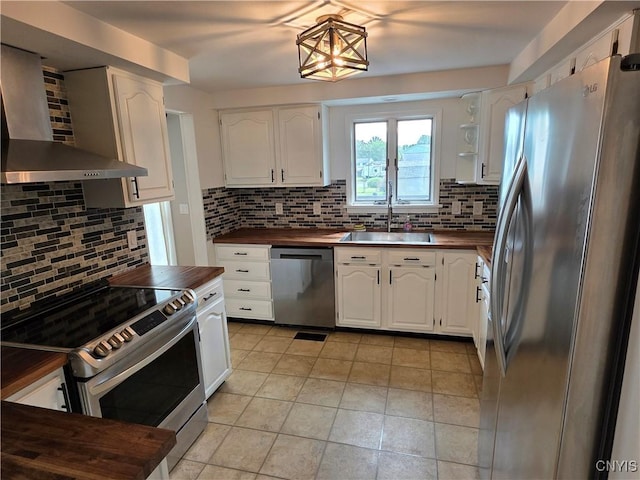 3978 Thrush Ln, Clay, NY 13090 - kitchen featuring appliances with stainless steel finishes, wall chimney range hood, decorative backsplash, and white cabinetry