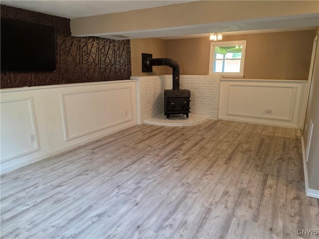 3978 Thrush Ln, Clay, NY 13090 - basement featuring a wood stove, wood finished floors, and wainscoting