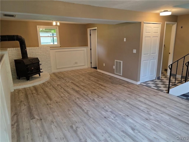 3978 Thrush Ln, Clay, NY 13090 - unfurnished living room featuring stairway, wood finished floors, and a wood stove
