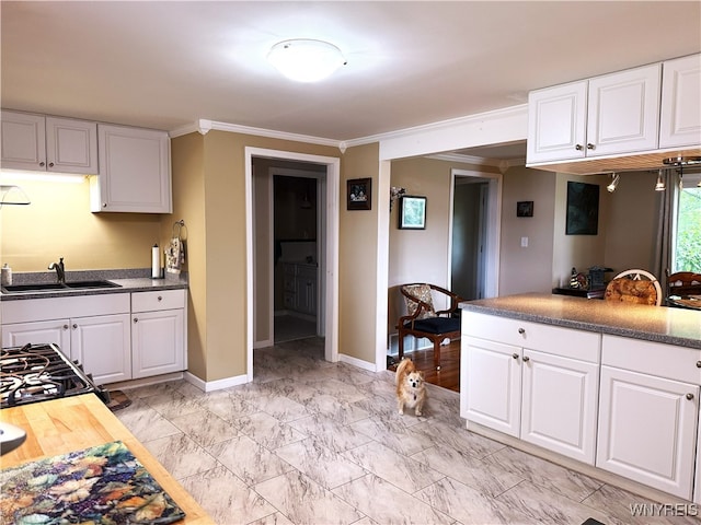 653 S S Colony Rd, Grand Island, NY 14072 - kitchen with crown molding, white cabinets, gas stove, and light marble finish floors