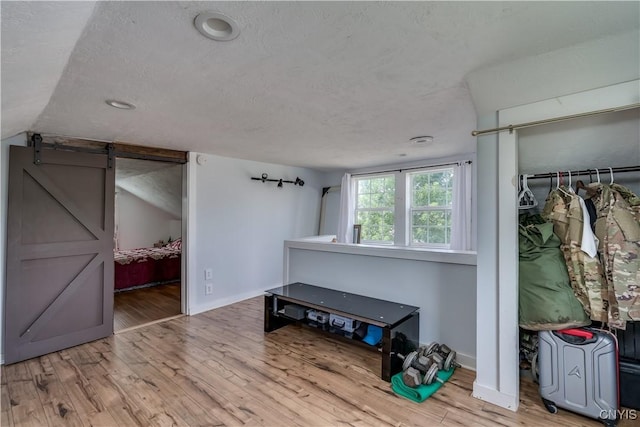 13051 State Route 3, Hounsfield, NY 13685 - bedroom with wood finished floors, a barn door, a textured ceiling, lofted ceiling, and recessed lighting