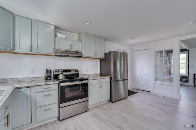 13051 State Route 3, Hounsfield, NY 13685 - kitchen with stainless steel appliances, under cabinet range hood, light wood-type flooring, and light stone counters