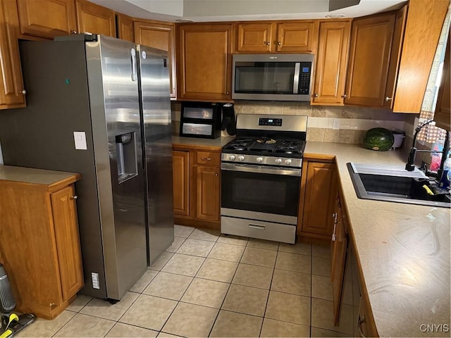 10 N 8th St, Fulton, NY 13069 - kitchen with stainless steel appliances, brown cabinets, and light tile patterned floors