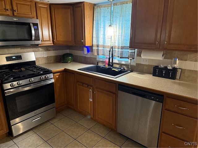 10 N 8th St, Fulton, NY 13069 - kitchen featuring appliances with stainless steel finishes, light countertops, light tile patterned flooring, brown cabinetry, and backsplash