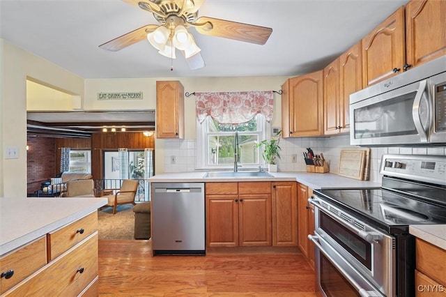 419 Bronson Rd, Geddes, NY 13219 - kitchen featuring stainless steel appliances, light countertops, light wood-style flooring, and backsplash