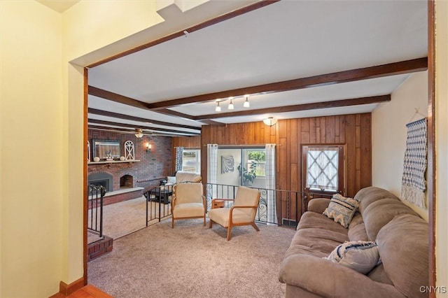 419 Bronson Rd, Geddes, NY 13219 - carpeted living room featuring a fireplace, beam ceiling, and wood walls