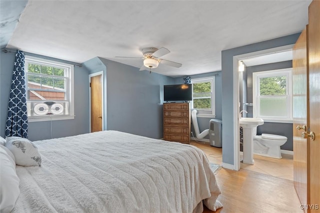 419 Bronson Rd, Geddes, NY 13219 - bedroom featuring multiple windows, light wood-style flooring, a ceiling fan, and ensuite bath